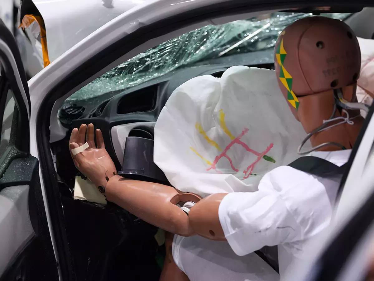 crash test dummy with broken window and airbag deployed